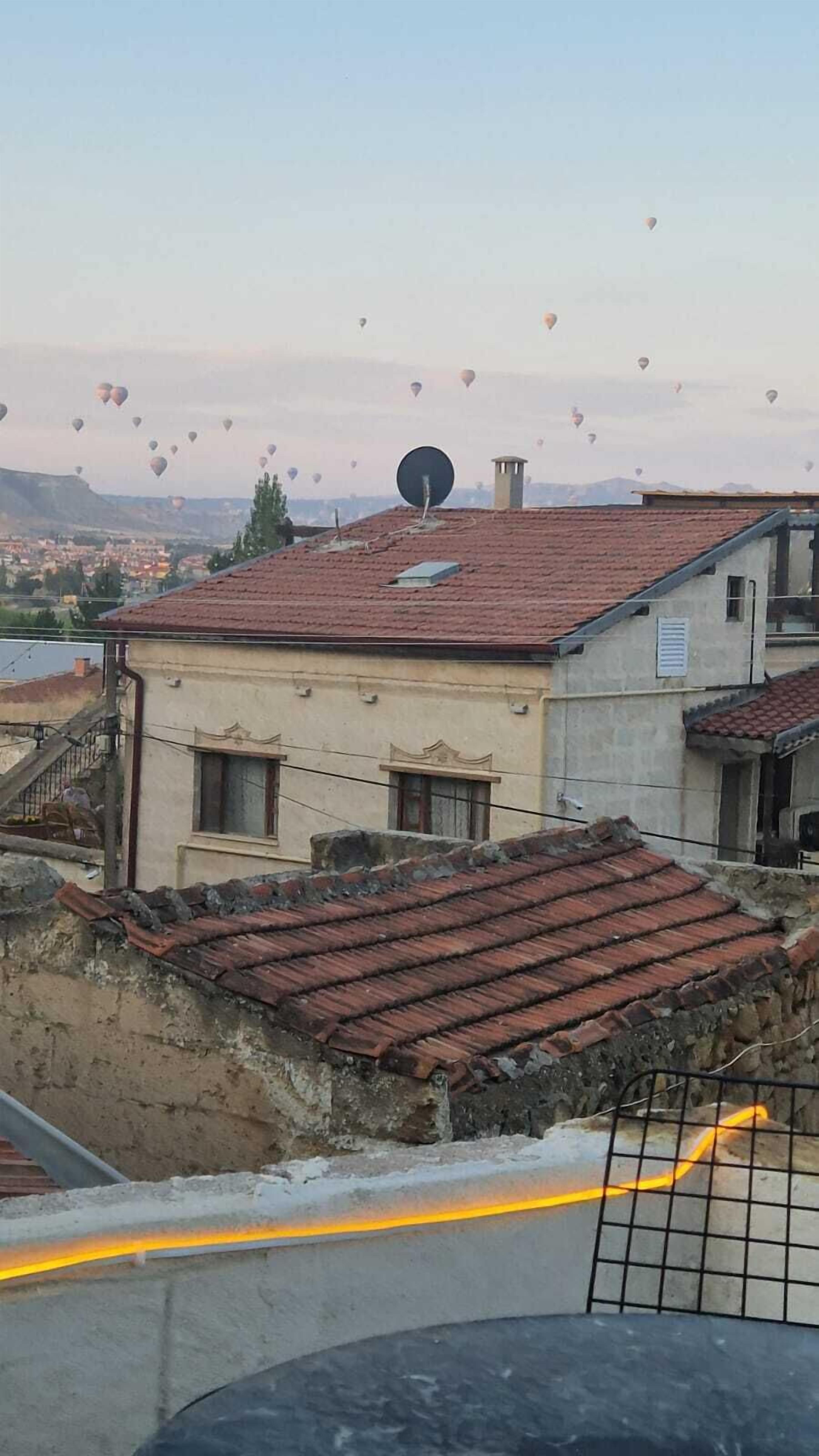 A building with a red-tiled roof and a satellite dish.