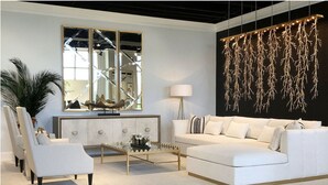 Uma sala de estar moderna com um sofá branco, poltronas, uma mesa de centro, um espelho grande e uma luminária de design exclusivo.