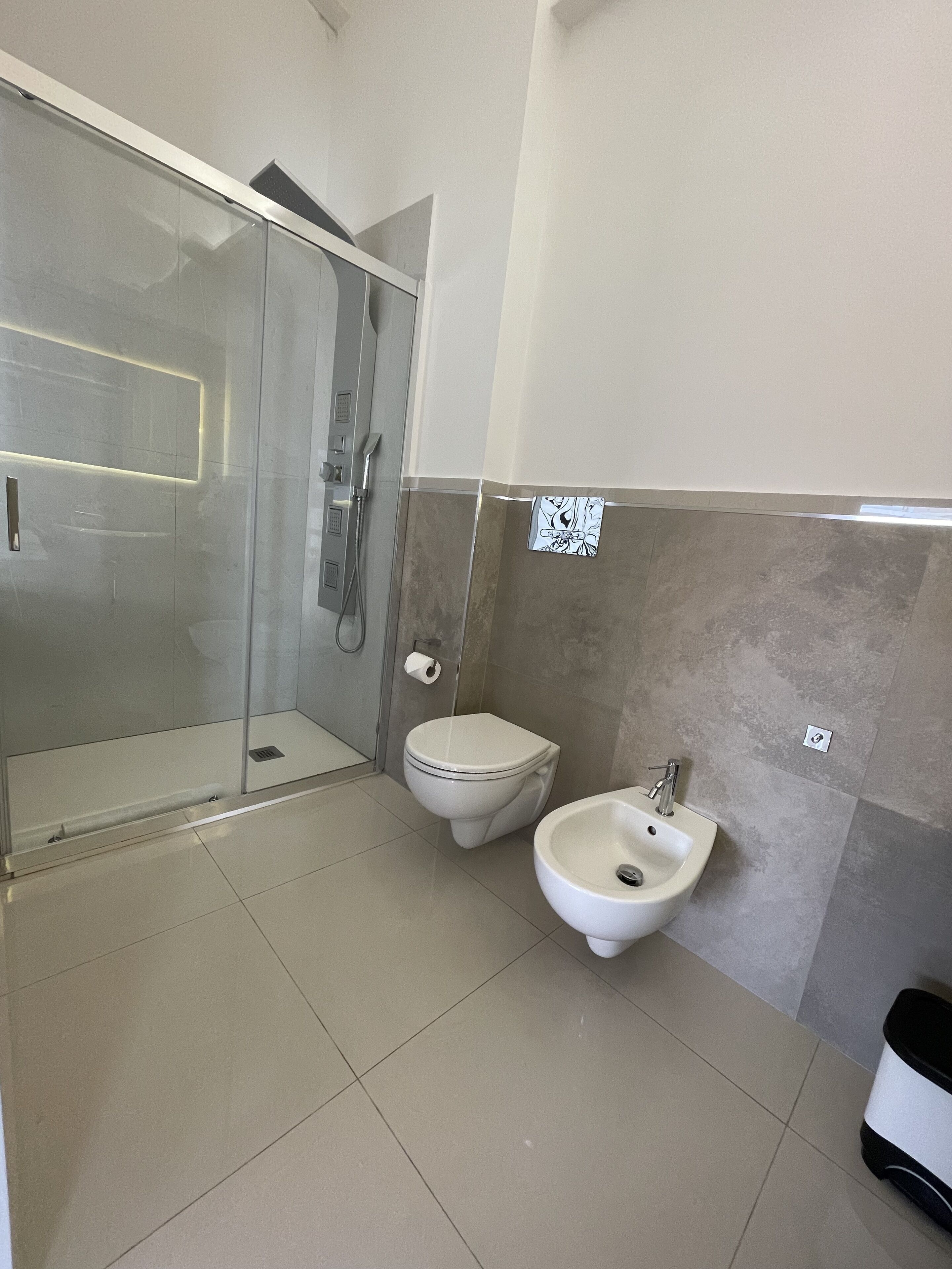 Et moderne badeværelse med bruseniche, toilet og bidet.