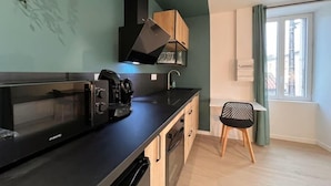 Uma cozinha compacta com micro-ondas, cafeteira e armários de madeira.