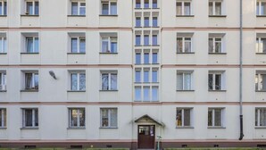 A multi-story residential building with a symmetrical facade, evenly spaced windows, and a central entrance.