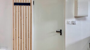 Ein Zimmer mit einer weißen Tür, einer Wand aus Holzlatten und einer weißen Klimaanlage an der Wand.