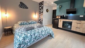 Ein modernes Schlafzimmer mit einem Bett, Nachttischlampen und einem kleinen runden Tisch.