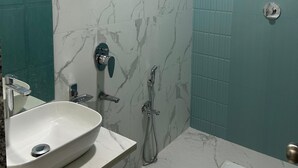 A bathroom with a white sink, a shower, and a toilet. - Ayarkar Farm Resort (Murud)