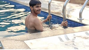 A person in a swimming pool with metal handrails. - Ayarkar Farm Resort (Murud)