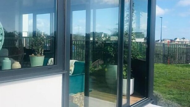 A modern building with large glass windows, a flat roof, and a white exterior wall. - ''dolmen'' (Plobannalec-Lesconil)