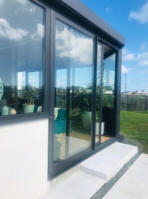 A modern building with large glass windows, a flat roof, and a white exterior wall. - ''dolmen'' (Plobannalec-Lesconil)