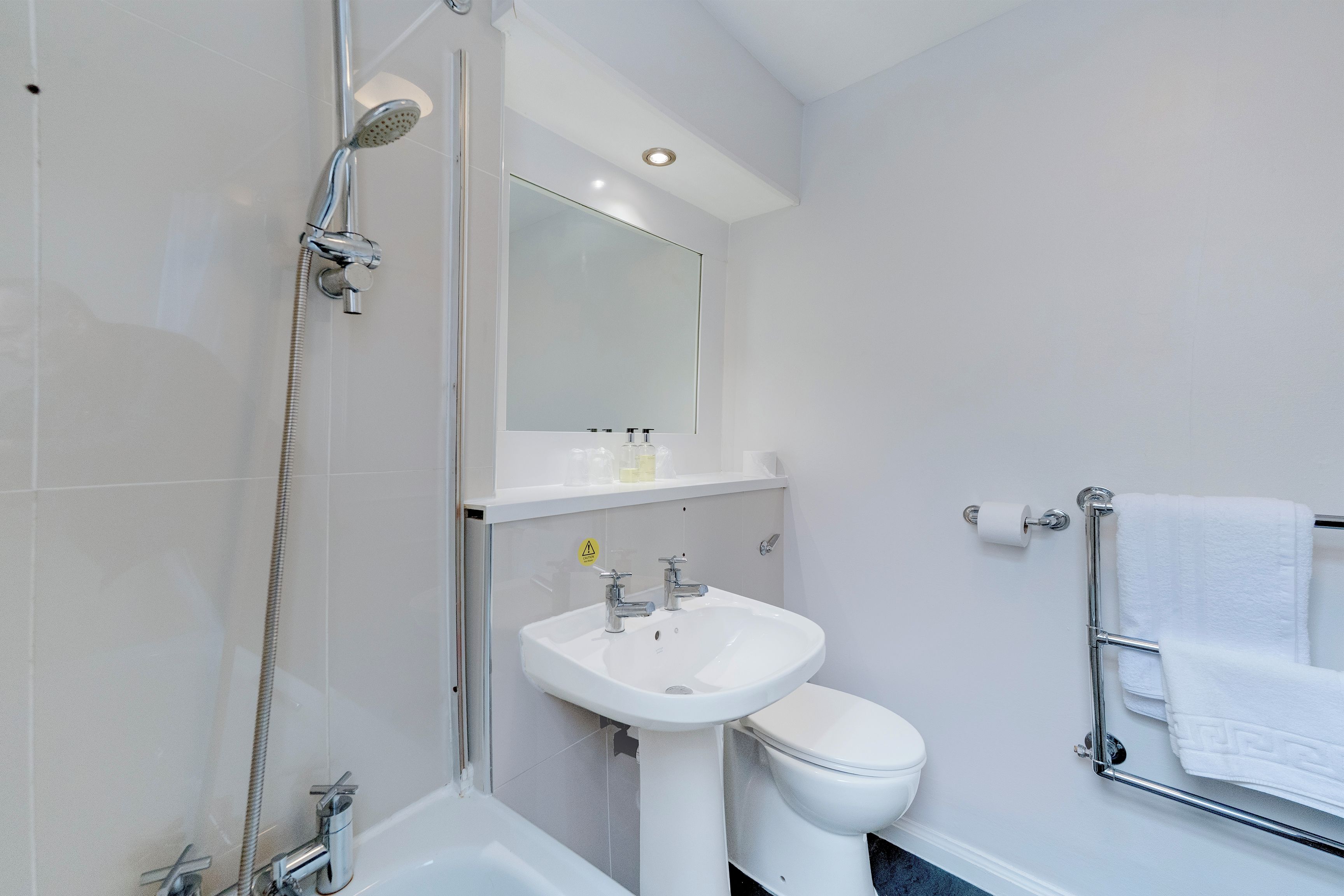A modern bathroom with a bathtub, a sink, and a toilet.