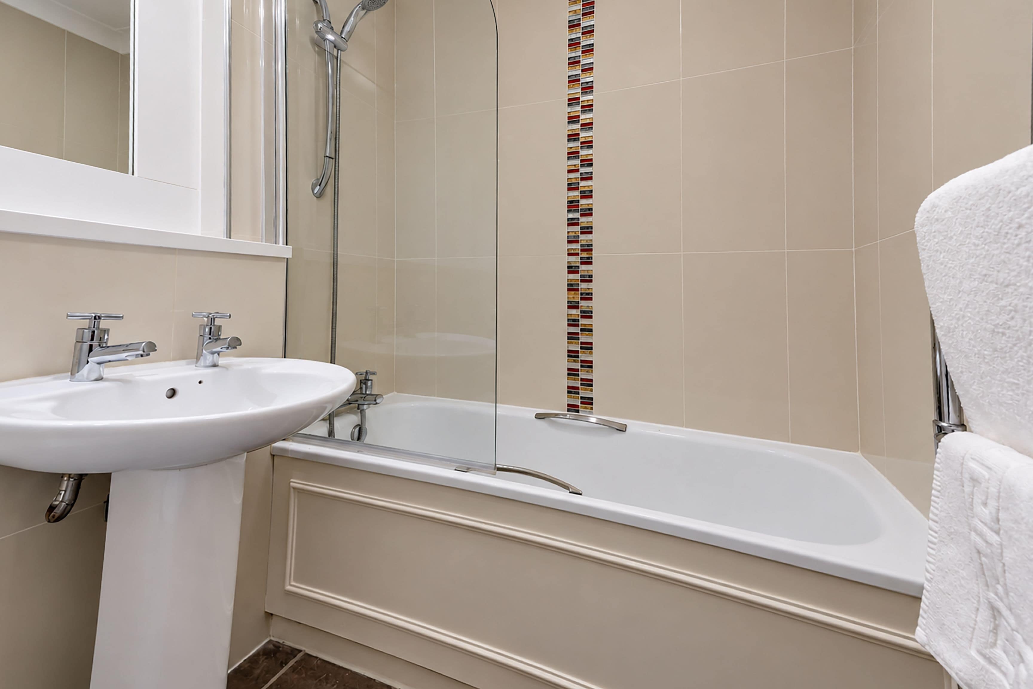 A bathroom with a white sink, a bathtub, and a shower.