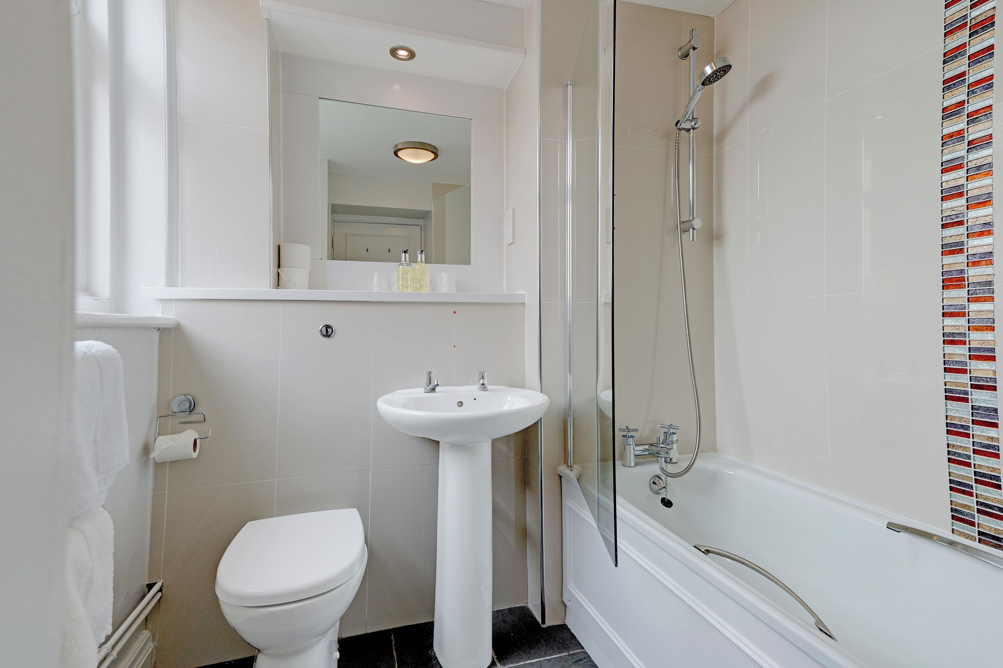 A bathroom with a toilet, sink, and shower.