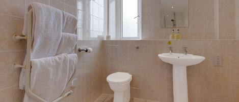 A bathroom with a toilet, sink, and towel rack.