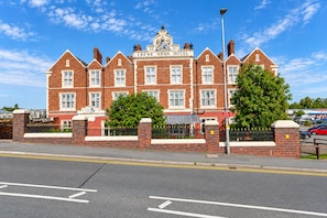 A red-brick hotel with a prominent crest and the name 'CREWE ARMS HOTEL' on the facade. - Belvilla Crewe Arms Hotel (Crewe)