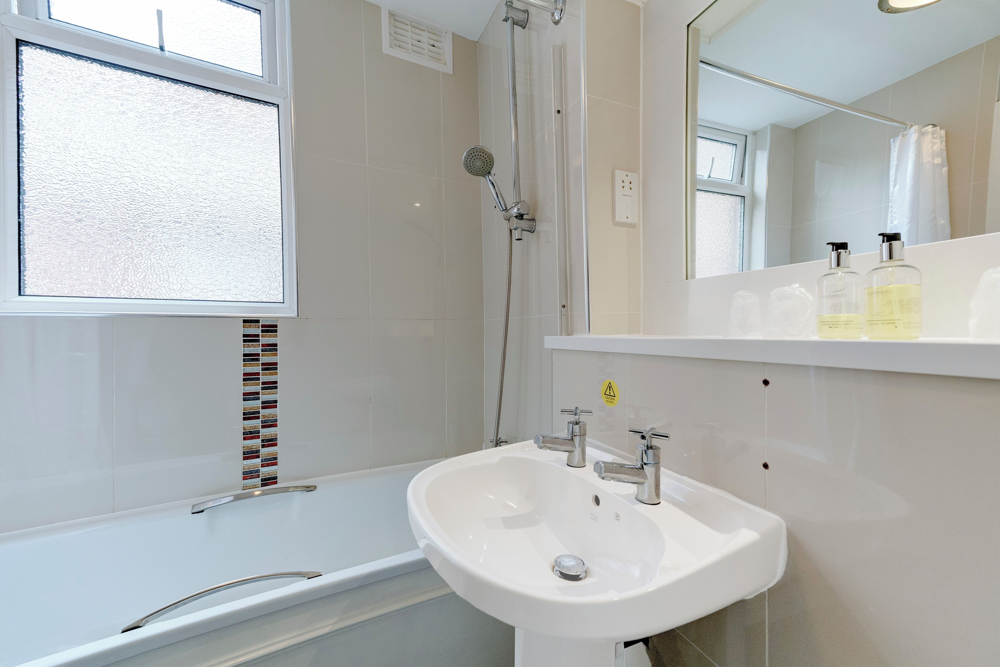 A bathroom with a bathtub, a sink, and a shower.