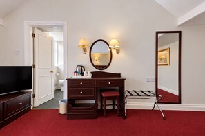 A hotel room with a large bed, a desk with a mirror, a television, and a red carpet. - Belvilla Crewe Arms Hotel (Crewe)
