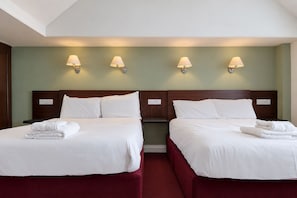 A hotel room with two beds, each with white linens and a neatly folded towel. There are wall-mounted lamps above each bed. - Belvilla Crewe Arms Hotel (Crewe)