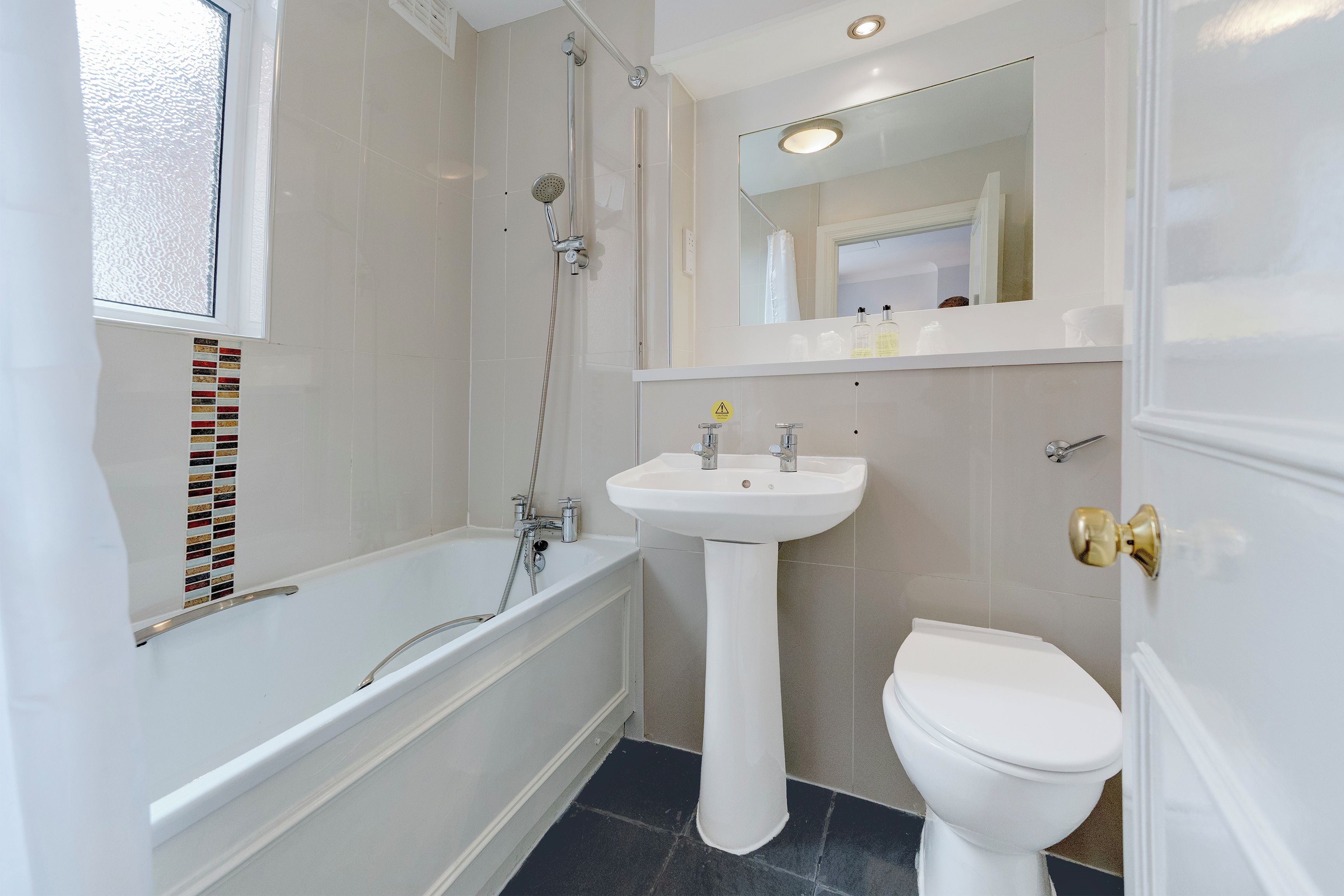 A bathroom with a bathtub, a sink, and a toilet.