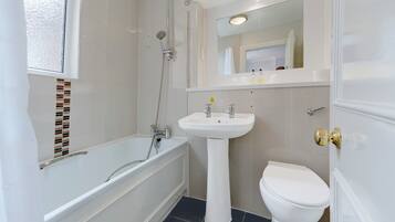 A bathroom with a bathtub, a sink, and a toilet.