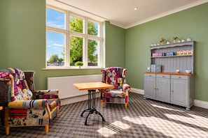 A room with a window, two chairs, a table, and a cabinet. - Belvilla Crewe Arms Hotel (Crewe)
