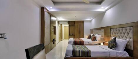 Une chambre d’hôtel avec deux lits, un ventilateur de plafond et un design moderne.