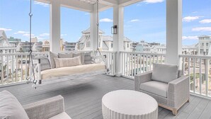 A covered outdoor balcony with a sofa, chairs, and a hanging light fixture. - Pet-Friendly Home@Cinnamon Shore South w/ Gulf View & Extras Galore! (Port Aransas)