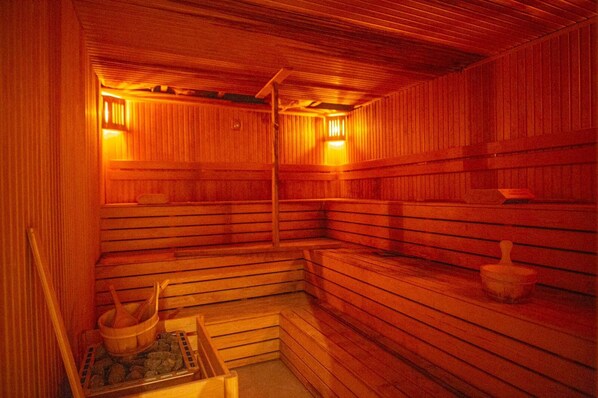 A sauna with wooden benches and a stone basin.