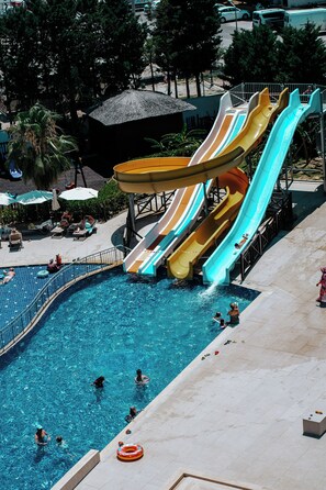 Una piscina con múltiples toboganes y zonas de descanso.