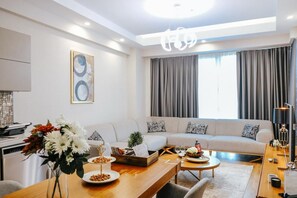 A modern living room with a sofa, coffee table, and dining area.