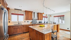 Una cocina amplia con armarios de madera, encimera de granito y una isla grande.