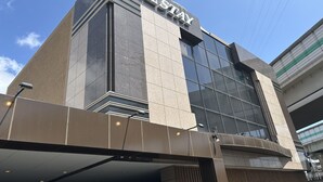 A modern hotel building with a prominent 'HOTEL STAY' sign on the facade.