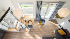 Una sala moderna con comedor, ventanas amplias y vistas al exterior.
