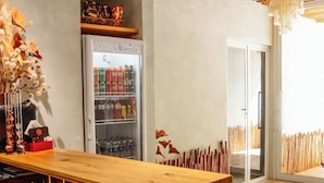 Una cocina moderna con una isla de madera, un refrigerador y un comedor con sillas.