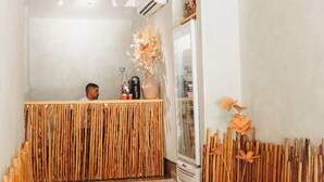 Una zona de recepción con un mostrador de madera, una lámpara de araña blanca y un diseño interior moderno.