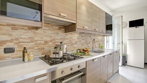 A modern kitchen with a gas stove, oven, and stainless steel appliances. - Monopoli Beach House 200 m From the sea (Monopoli)
