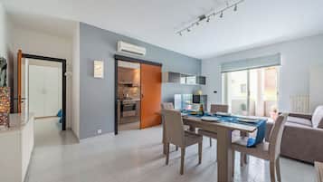 Un espace de vie moderne comprenant un coin repas, une cuisine et une vue sur l’extérieur.