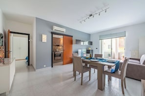 A modern living space with a dining area, kitchen, and a view to the outside. - Monopoli Beach House 200 m From the sea (Monopoli)