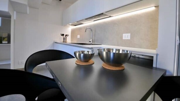 Une cuisine moderne avec deux bols en acier inoxydable posés sur une table, un évier et un plan de travail.
