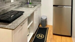 A modern kitchen with a stainless steel refrigerator, a built-in oven, and a granite countertop. - Seawind Condo 2 BR Near Airport & Samal (Davao)