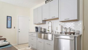 A modern kitchen with white cabinets, stainless steel appliances, and a tiled backsplash. - Cozy 3 bedroom - Free Parking, close to buses.  (Boston)