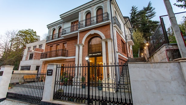 A two-story hotel with a brick facade, arched windows, and a balcony. - LILEO Hotel (Kutaisi)