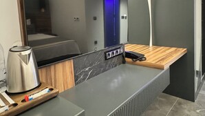 A modern kitchen with a built-in microwave, a coffee maker, and a wooden countertop. - Telmessos City Hotel ADULTS ONLY (Fethiye)