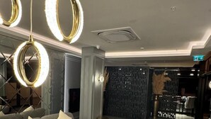A modern interior with a sectional sofa, a wooden table, and a decorative wall. - Telmessos City Hotel ADULTS ONLY (Fethiye)