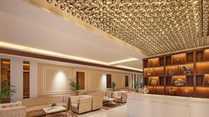 A spacious lobby with a high ceiling, a reception desk, and a seating area with sofas and a coffee table. - Regenta Place Gwalior (Gwalior)