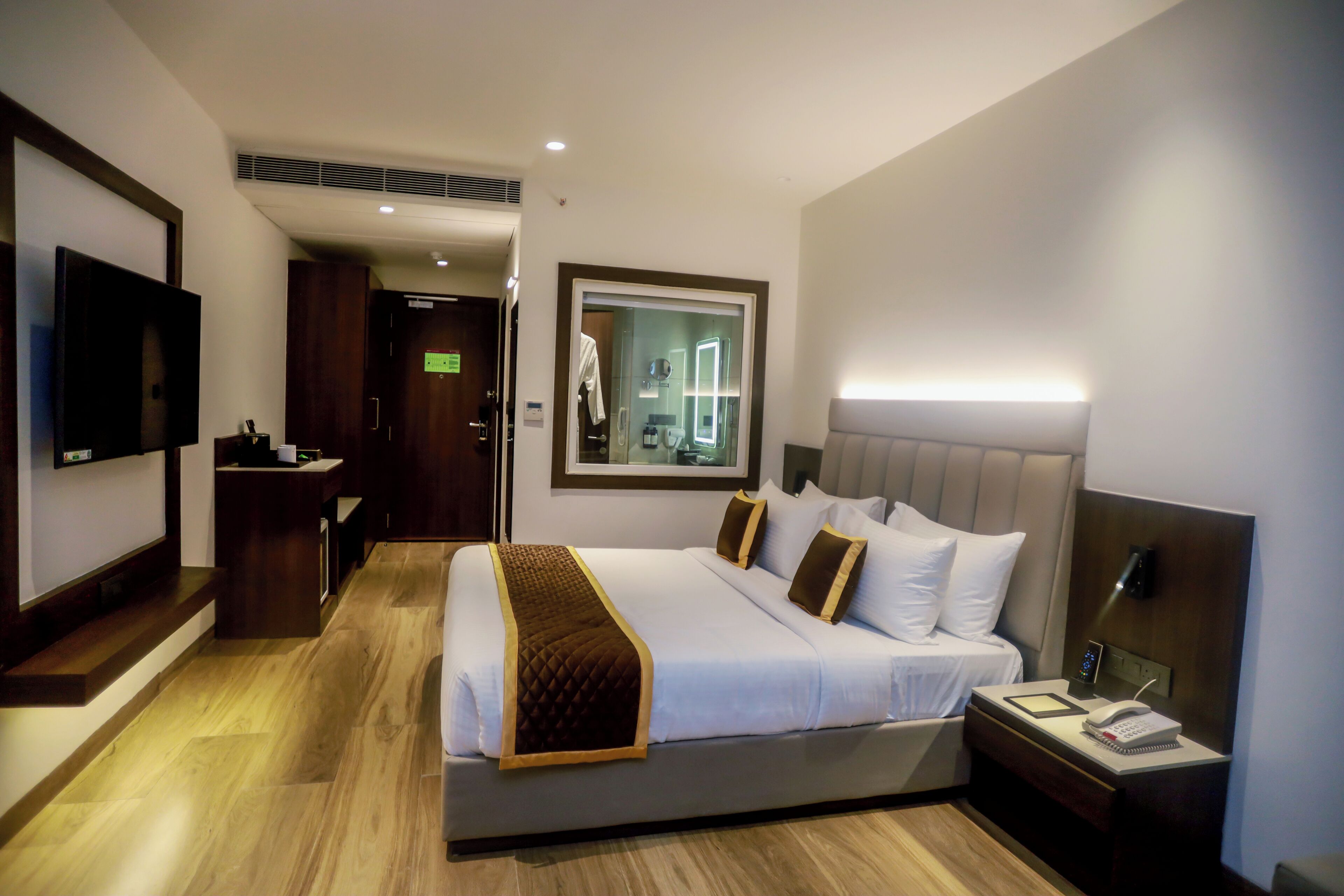 Ein Hotelzimmer mit einem großen Bett, einem Nachttisch und einem Fernseher.