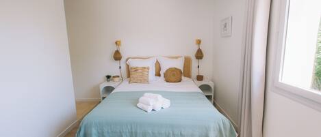 Une chambre à coucher avec un lit, des tables de chevet et une fenêtre.