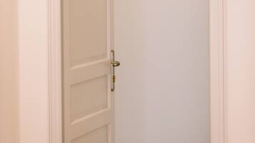 Una puerta blanca con un pequeño cuadro enmarcado de un flamenco en la pared.