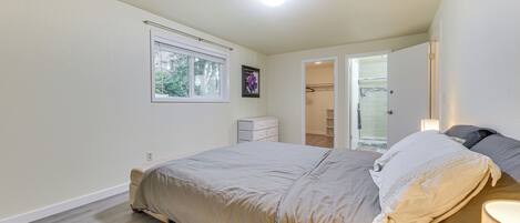 A bedroom with a bed, a window, a dresser, and a closet.
