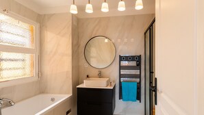 A modern bathroom with a bathtub, a sink, a mirror, and a towel rack. - Cap Ferrat View III AP4401 By Riviera Holiday Hom (Saint-Jean-Cap-Ferrat)