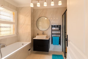 A modern bathroom with a bathtub, a sink, a mirror, and a towel rack. - Cap Ferrat View III AP4401 By Riviera Holiday Hom (Saint-Jean-Cap-Ferrat)