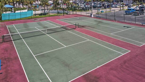 A tennis court with multiple courts, a net, and surrounding parking area. - Oceanfront Panama City Beach Condo w/ Pool Access (Panama City Beach)