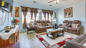 A spacious living room with a brown leather sofa set, a wooden coffee table, and a ceiling fan. - Furnished Patio! Retreat 12 Mi to Dtwn Phoenix (Laveen)